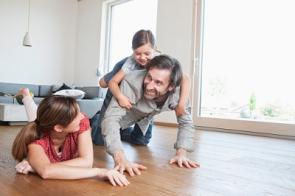 Vater und Mutter spielen im Wohnzimmer mit Kind