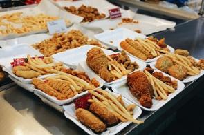 Teller mit Fast-Food-Gerichten sind auf einem Tisch ausgestellt.