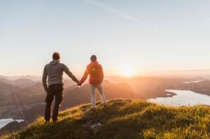 Paar auf Berggipfel vor Sonnenuntergang