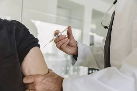 Arzt gibt älterem Patienten eine Impfung