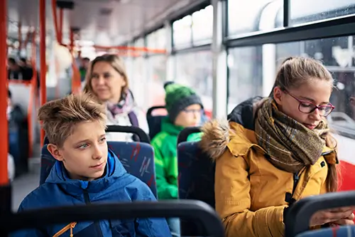 Kinder und Jugendliche sitzen in einem Bus.