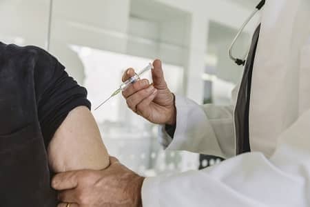 Arzt gibt älterem Patienten eine Impfung