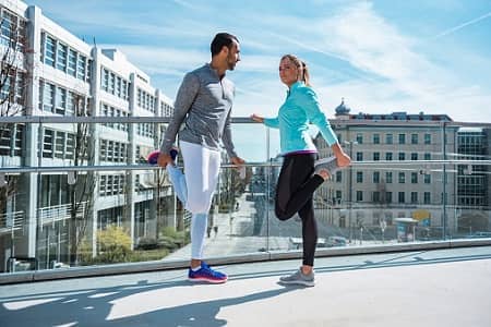 Mann und Frau machen Dehnübungen beim Sport