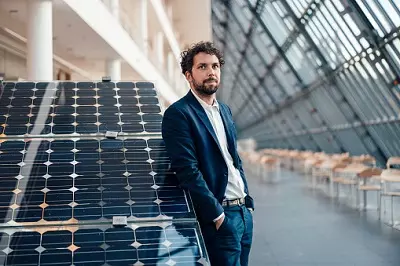 Unternehmer vor Solarpanel: Unfallversicherung für Selbstständige