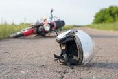 Ein umgekipptes Moped und ein Helm liegen auf einem Feldweg.