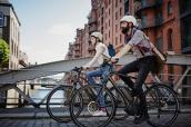 Junges Paar fährt mit E-Bikes durch Hamburg.