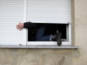 Mann klettert am Fenster