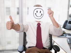 Mann mit Smiley im Büro