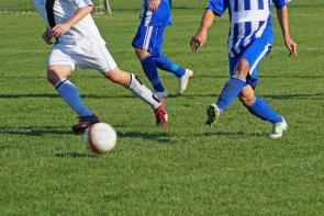 Fußballspieler beim Spiel auf Rasen.