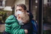Vater und kleiner Sohn mit Atemschutz-Maske.