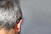 Älterer Mann trägt ein Hörgerät.