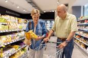 Seniorenpaar mit Einkaufswagen im Supermarkt
