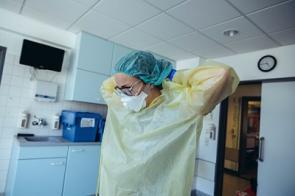 Ärztin zieht Schutzkleidung im Krankenhaus an.
