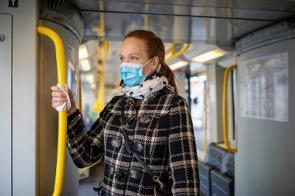 Junge Frau während Covid-19-Ausbruch mit Maske in der U-Bahn
