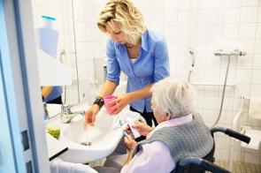 Pflegerin mit Heimbewohnerin im Bad