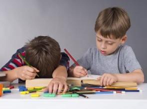 Zwei Jungen mit Buch und Spielzeug