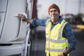Lkw-Fahrer steht vor seinem Fahrzeug.