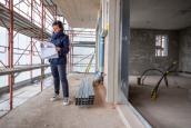 Frau steht auf einer Baustelle