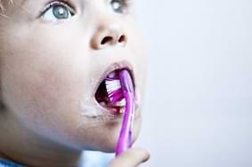 Kind putzt Zähne mit Zahnbürste