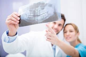 Zahnärzte betrachten Röntgenbild eines Kiefers