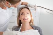 Eine Zahnärztin behandelt eine lächelnde Patientin.