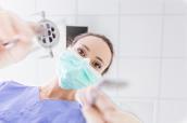Zahnärztin mit Maske aus Perspektive des Patienten