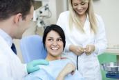 Zahnarzt mit Patientin und Helferin